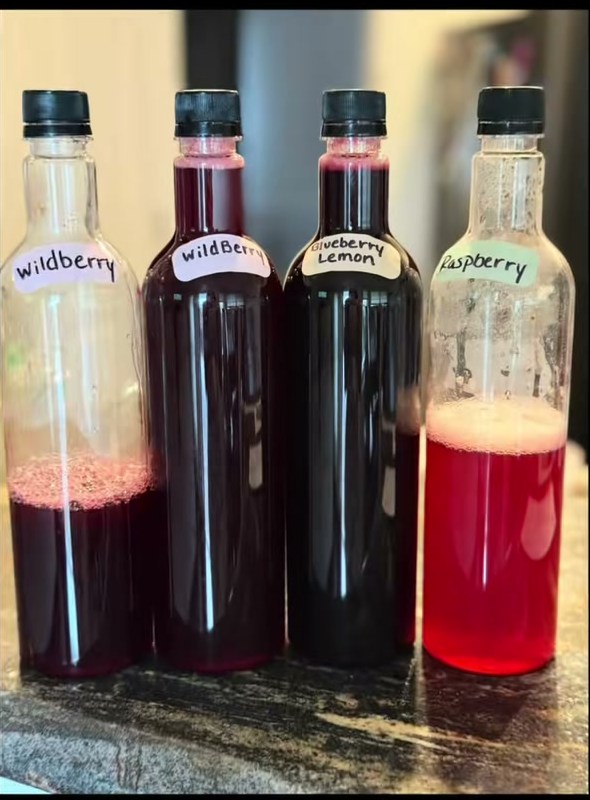 Hand-labeled bottles of homemade syrup: wildberry, blueberry lemon and raspberry